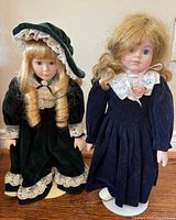 Both dolls side by side on stands