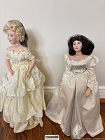 Full view of both porcelain dolls standing side by side