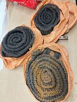 Three orange bags each containing a coil of looped steel ties