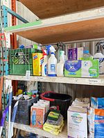 Shelved cleaning supplies including cleaners, sprays, Swiffer cloths, SOS pads, microfiber pads, towels, mop bucket