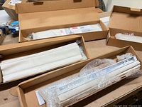 Boxes containing folded fabric Roman shades and wrapped headrails