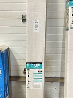 Front of sealed Trimaco E-Z UP dust containment pole box