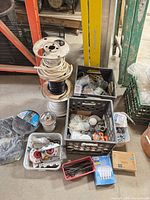 Overall lot showing stacked spools of wire, crates and bins of hardware, LED bulb packaging