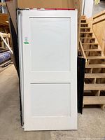 Front view of white two-panel door slab standing upright