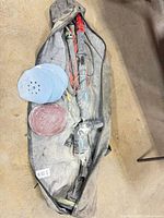 Overhead view of sander inside carry bag with discs visible