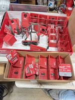 Overview of upper tray and lower box showing red PACKOUT bins, trays and gray hooks