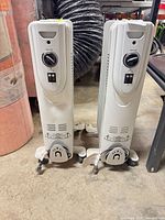 Front view of both oil-filled heaters showing controls and casters