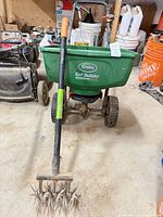 Full view of broadcast spreader and cultivator showing both items in lot
