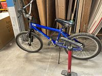 Full view of blue Supercycle bicycle with Bell pump beside it