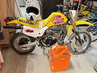 Side view of Suzuki DS80 dirtbike with Matrix fuel can beside it