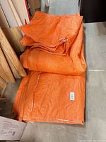 Stacked orange tarp folded on floor