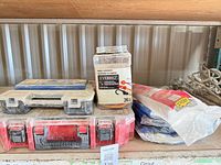 Shelf view of two organizer boxes, Everbilt jar with cords, and window sealant packs