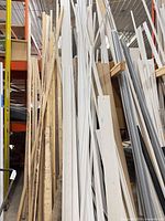 view of bulk lot showing painted white trim boards and raw lumber pieces stored vertically