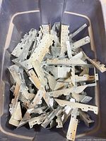 Top view of plastic bin filled with assorted galvanized steel connectors