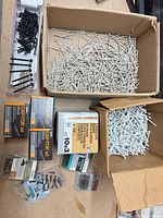 Overview showing Cap-Tor xd screw boxes, two cartons of gray nails, bag and blister packs of screws