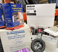 Boxes of Broan NuTone roof cap, Reversomatic wall cap, ProMax dryer vent kits, vent grilles, fan wheel