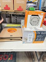 Lot overview showing Hampton Bay fan box, Schluter grate box, two Schluter valve seals