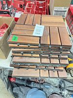 Stack of nine wood deck tiles showing top surface and interlocking edges