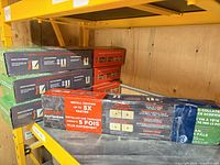 Stacked green and multicolour CAMO screw boxes on shelf