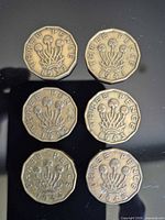 Reverse sides showing dates and crowned thrift design of six three-pence coins