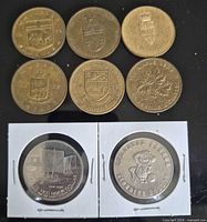 Obverse sides of six loose Centennial tokens and obverse of two festival dollars in 2×2 holders