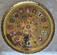Front view of brass plate showing map and coats of arms