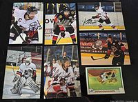 Front view of six autographed Bulldogs photo cards with size-reference card