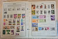 Two album pages filled with multicolour Rwanda mint stamps of famous persons, art, sports, wildlife