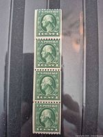 Front view of four connected green 1-cent Washington coil stamps