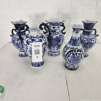 Group view of all five matching blue and white vases