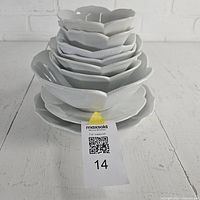 Stacked view of all nine lotus-shaped bowls and plates
