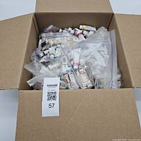Open box showing large quantity of watercolor tubes in zipper bags
