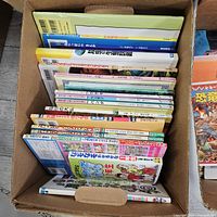 Two cartons filled with assorted Japanese children’s books, spines visible