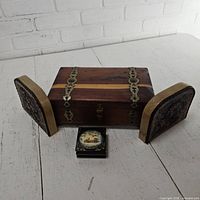 Closed hardwood jewelry box flanked by pair leather bookends with lacquer box in front