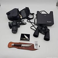 All items overview: camera with bag, binoculars, pocket knife, large knife with sheath