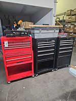 Front view of three rolling tool cabinets with grey toolbox and black puller case on top