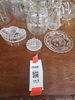 Front view showing small dishes, trinket box, etched plate with additional glass items behind