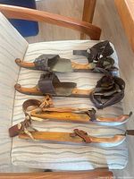 Overview of both pairs of antique wooden ice skates on chair