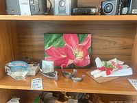Shelf view with oil painting, glass fish, metal Viking ships, trinket, candles and Hi-Q game