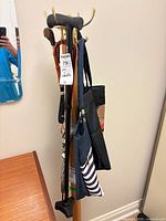 Overall view showing cane, umbrella, shoehorn, and two bags on stand