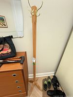 Full view of wooden coat rack beside furniture