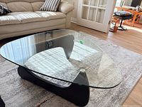 Full view of coffee table showing glass top and wood base