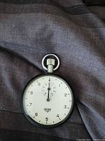 Front view Heuer stopwatch white dial black case