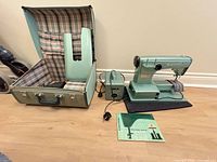 Full view of sewing machine with case, foot pedal and manual