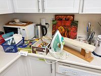 Steam iron, sleeve board and sewing notions grouped on countertop