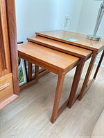 set of three teak nesting tables stacked