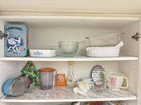 Cabinet shelves with full lot showing tins, bakeware, utensils