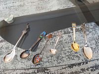 All six spoons laid out showing size and decoration