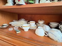 Overall view of china stacks, candle holder, crystal salts and matchbox on shelf