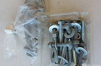 Plastic clamshell of bolts, washers and nuts beside bag of washers